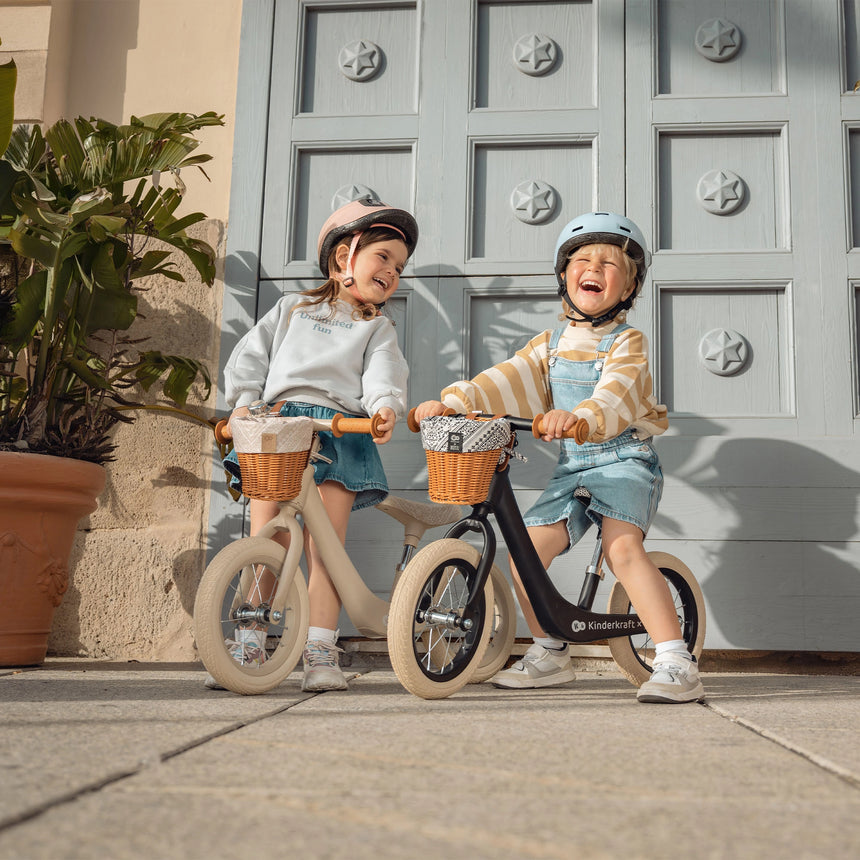 Toddler gliding on the lightweight Kinder Kraft Rapid 2 balance bike with basket