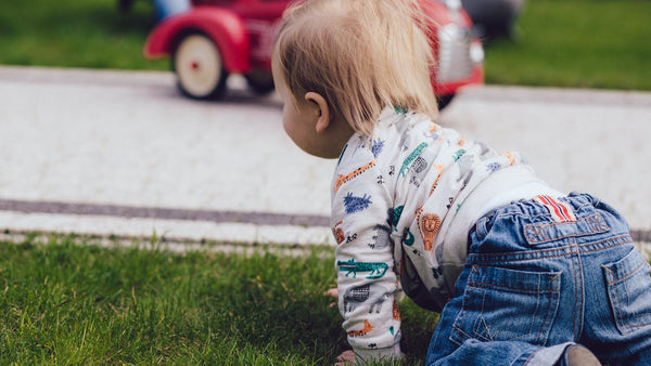 Happy toddler playing, ready for a first foot to floor push car