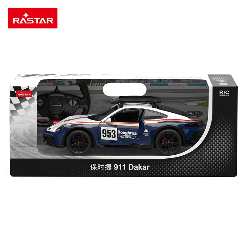 Rastar 1:14 Porsche 911 Dakar Performance RC car displayed in front of its retail packaging box, showing the car in white and navy blue #953 Roughroads Dakar livery from a front three-quarter angle with the roof rack, alongside the Porsche-branded box with the steering-wheel controller inset visible.