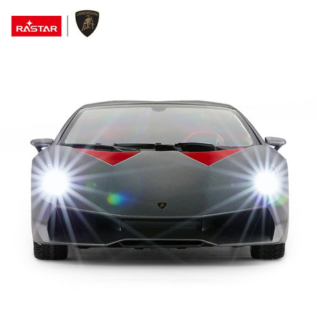 Rastar 1:14 Lamborghini Sesto Elemento RC car in dark grey shown front-on with both bright LED headlights illuminated, highlighting the aggressive front splitter and Lamborghini badge.