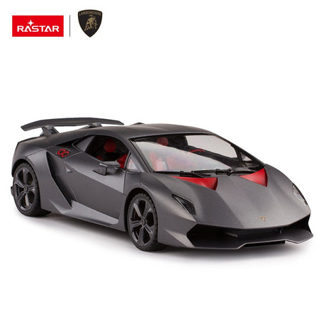 Rastar 1:14 Lamborghini Sesto Elemento RC car in matte grey photographed from the front 3/4 angle showing the large rear wing, open scissor-style door revealing the red interior with stereo and steering wheel details.