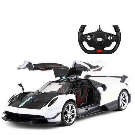 Rastar 1:14 Pagani Huayra BC RC car in white and carbon fibre finish, front 3/4 view with gull-wing doors fully open, displayed alongside the Rastar steering wheel radio controller.