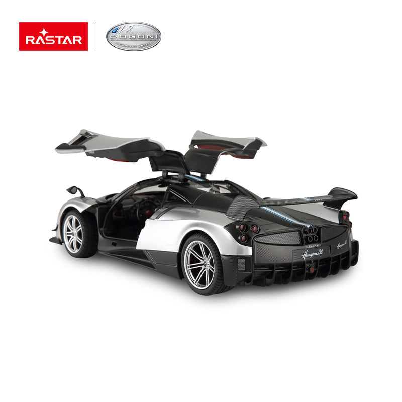 Rastar 1:14 Pagani Huayra BC RC car in silver and carbon fibre finish, rear 3/4 view with both gull-wing doors open, showing the rear diffuser, quad exhausts, and Huayra BC badging; Rastar and Pagani logos displayed above.