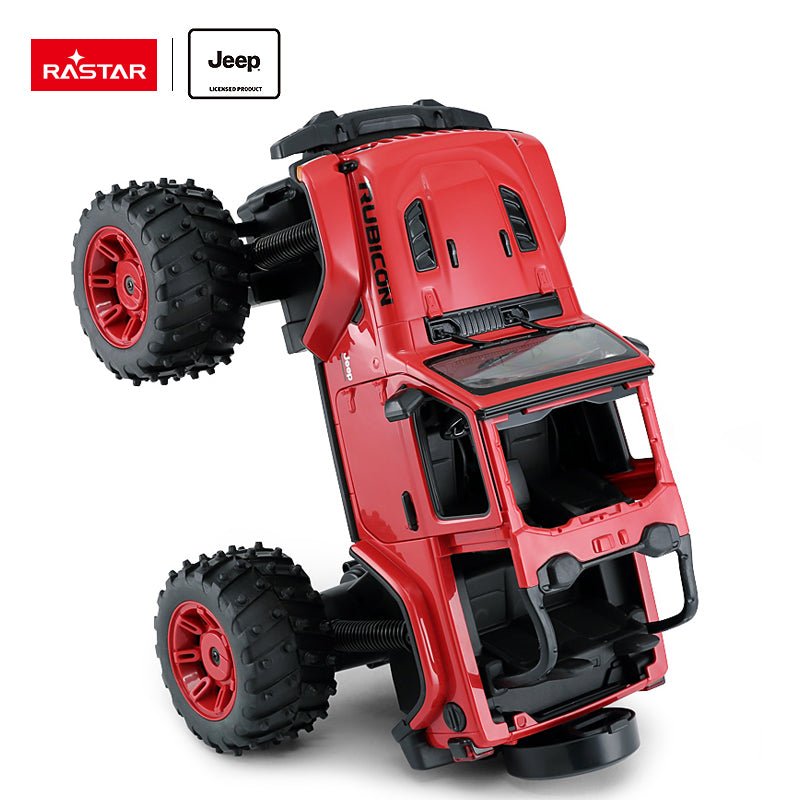 Rastar 1:14 Jeep Wrangler Rubicon Big Foot RC car in red tilted at a dynamic angle to demonstrate the extreme off-road suspension articulation, with the Rubicon graphics and open interior visible alongside the knobby bigfoot tyres and red rims.