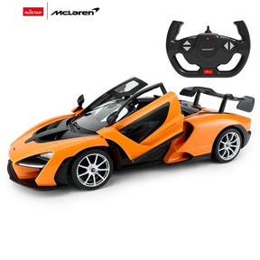 Rastar 1:14 McLaren Senna RC car in orange, front three-quarter view with both scissor doors open showing the interior, displayed alongside its McLaren-branded steering wheel controller.