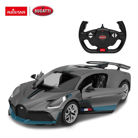 Rastar 1:14 Bugatti Divo RC car in matte grey with teal/blue accents shown from front 3/4 angle, displayed alongside its Bugatti-branded steering wheel remote controller. The car features the Divo's distinctive wide body, large rear wing, and French tricolour badge on the door sill.