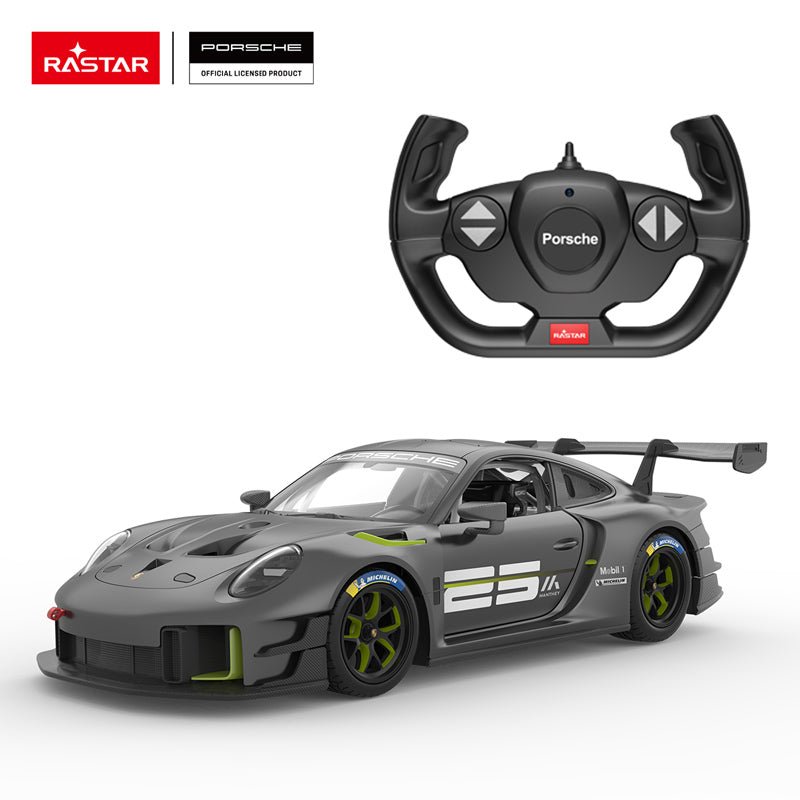 Rastar 1:14 Porsche 911 GT2 RS Clubsport 25 RC car in matte dark grey with neon green accents shown from front 3/4 angle alongside the Porsche-branded steering wheel remote controller. The car features Manthey Racing livery with the large "25" door number, Michelin and Mobil 1 sponsor logos, green-accented wheels, and a large carbon rear wing.