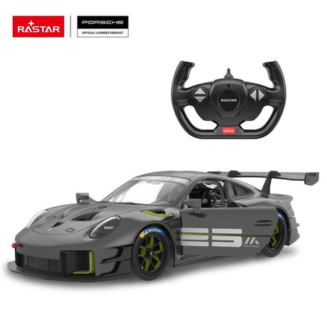 Rastar 1:14 Porsche 911 GT2 RS Clubsport 25 RC car in matte dark grey with neon green accents shown from a lower front 3/4 angle alongside the Rastar steering wheel controller. The Manthey "25" racing livery, carbon hood intake, Michelin-branded tyres, and prominent rear wing are clearly visible.