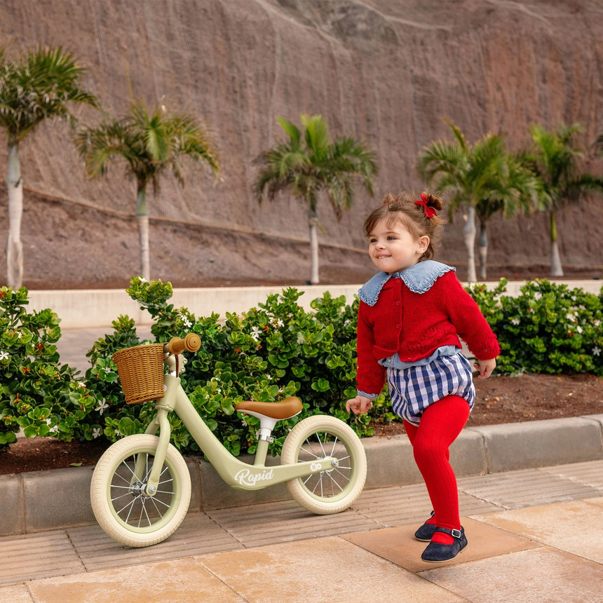 Toddler learning to balance on the Kinder Kraft Rapid 2 Whisper Dune bike outdoors