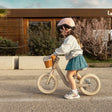 Child riding the Kinder Kraft Rapid 2 balance bike in Whisper Dune with front wicker basket