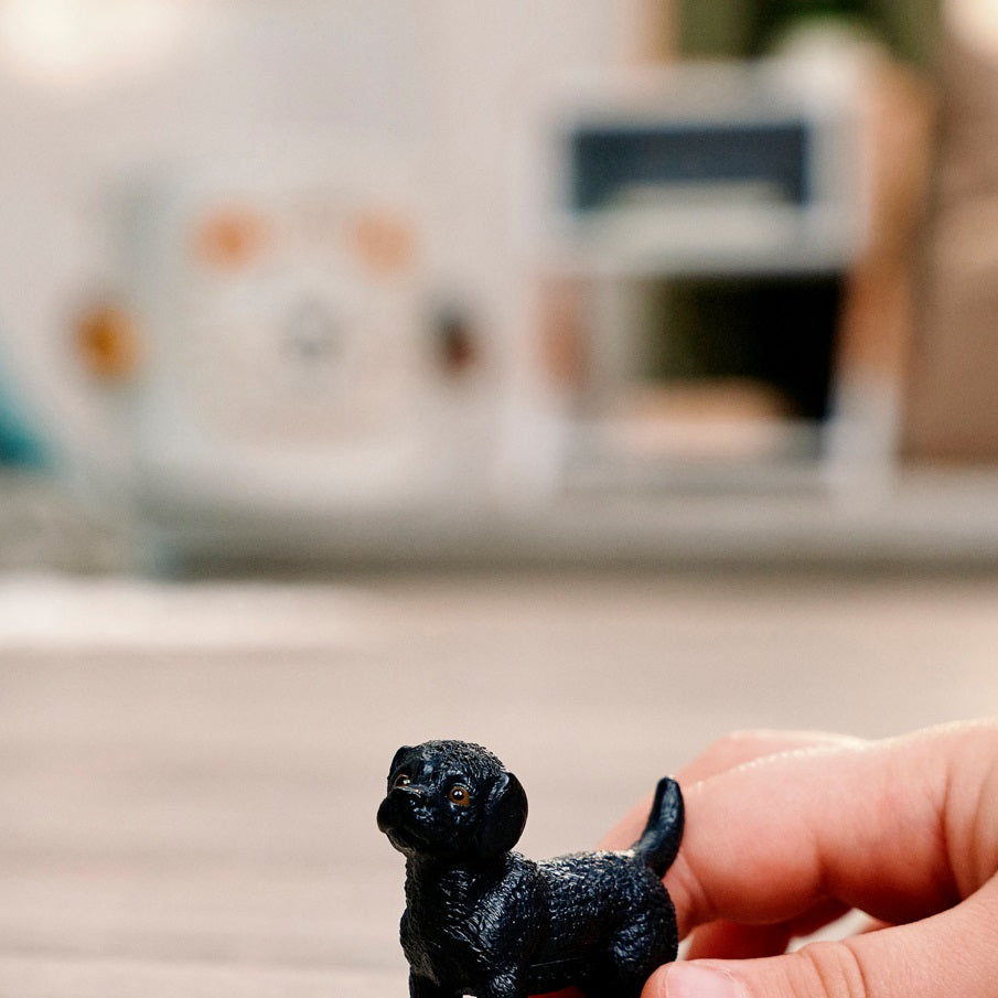 Schleich Black Labrador Retriever Puppy toy figure held during play