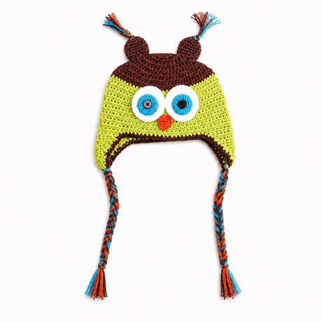 Crocheted owl hat with large embroidered eyes, a small orange beak, brown ear covers, and braided ear ties in blue, orange, and brown on a white background.