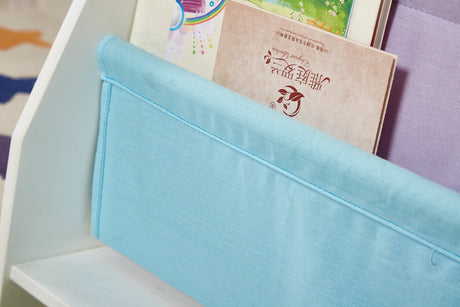 Detail of the blue canvas sling pocket on the Charlie White kids bookcase holding a storybook