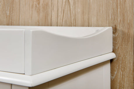 White wooden nursery changing table against a light wood wall