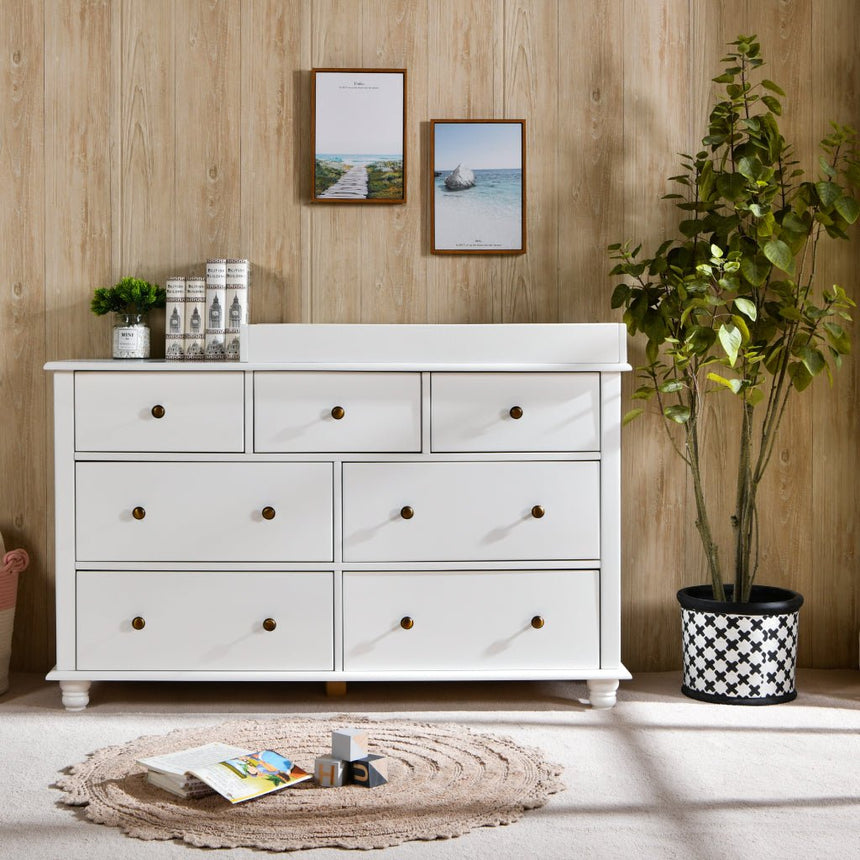 Modern nursery with white wooden dresser, indoor plant, and decorative wall art