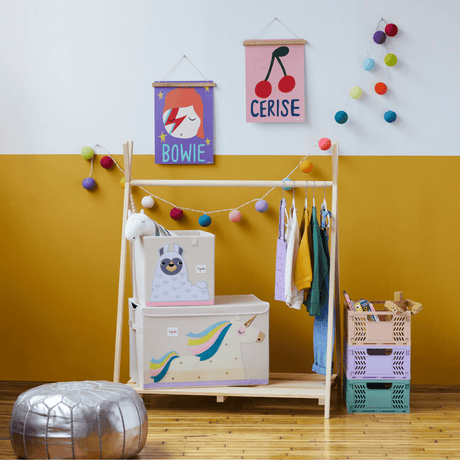 Children's room with a wooden wardrobe, colorful storage bins, and wall decorations.