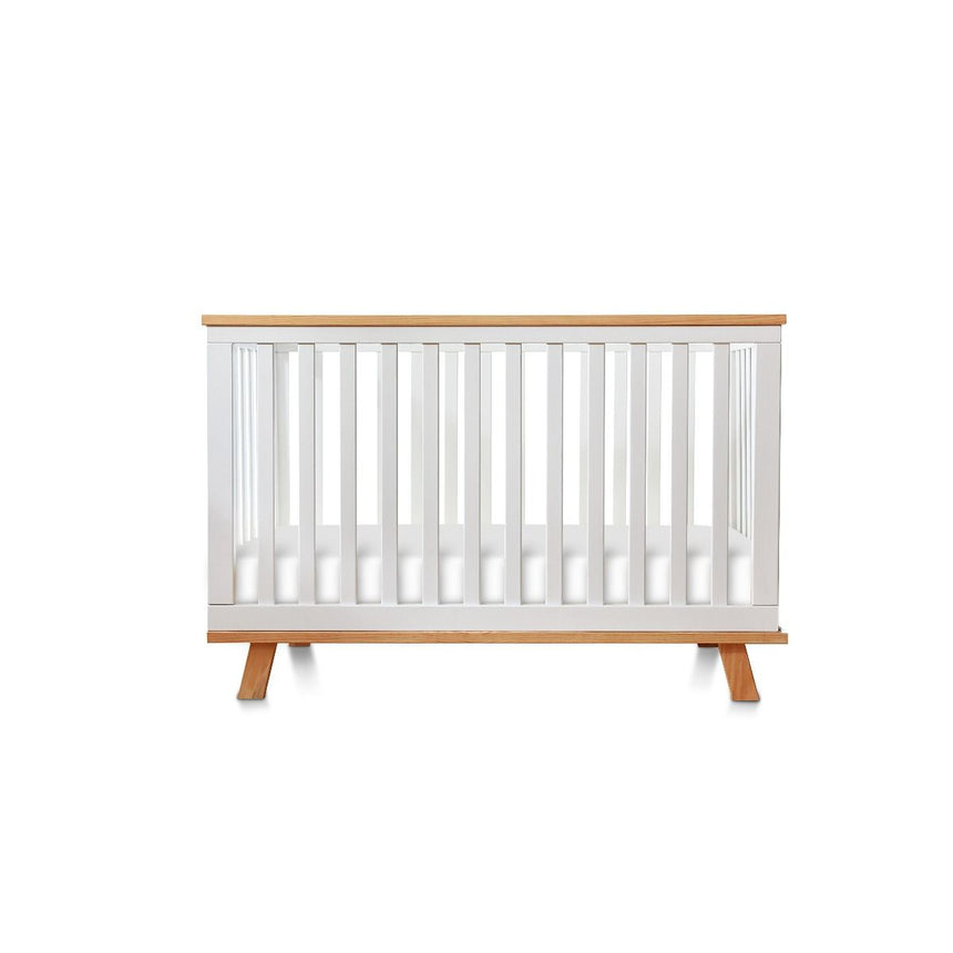 Modern white wooden baby cot with natural wood accents, nursery furniture