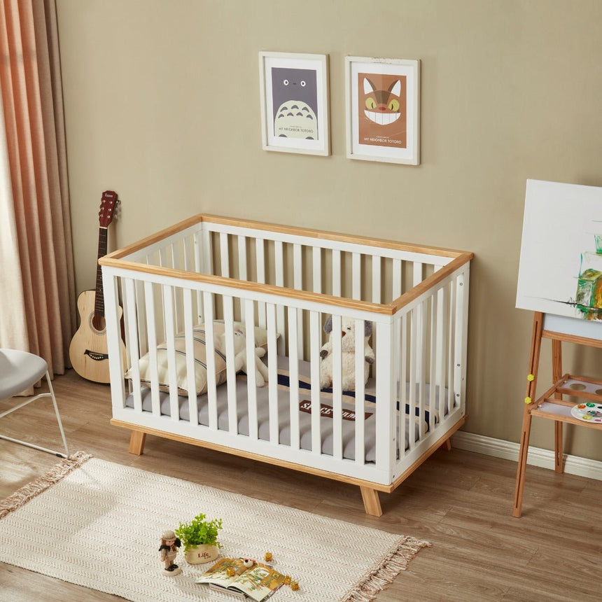Modern wooden baby cot in a cozy nursery with toys, artwork, and soft furnishings