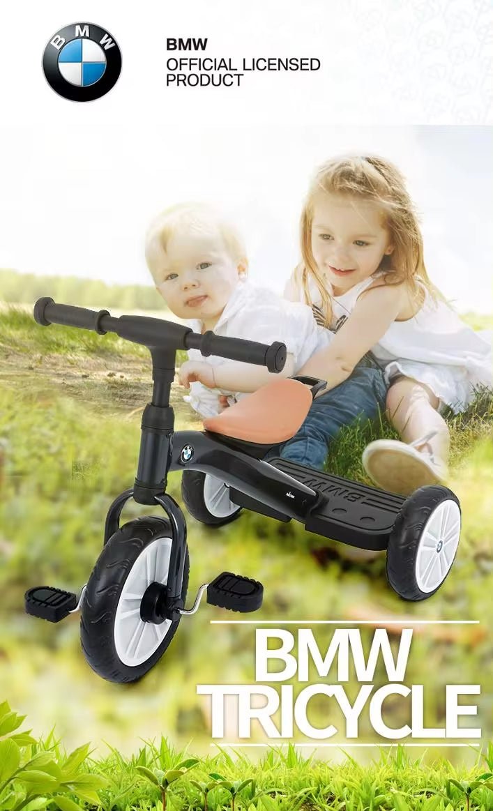 Children playing with a BMW tricycle in a grassy field, with the BMW logo visible.