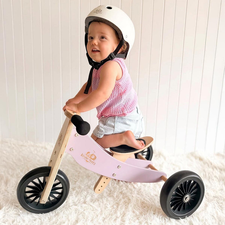 Toddler riding the Kinderfeets Tiny Tot Plus Lavender balance bike